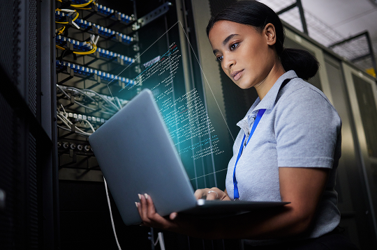 Engineer working on a laptop in a data center